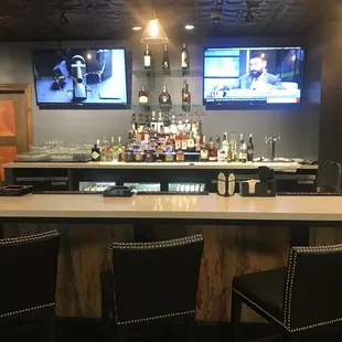 a bar with two televisions