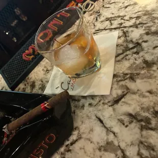 a glass of whiskey and a cigar