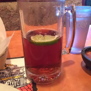 a glass of tea with a lime slice in it