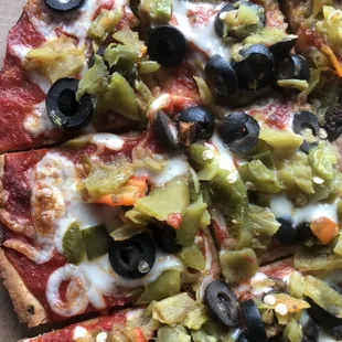 Cauliflower pizza with green chile, olives, and easy cheese.