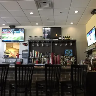 a bar with several televisions on the wall