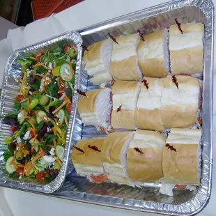 a tray of sandwiches and a salad