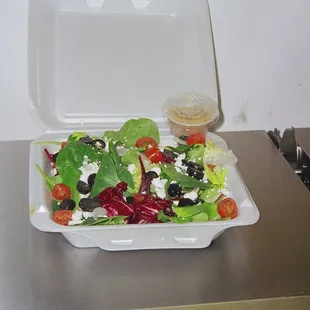 a salad in a styrofoam container