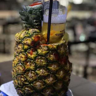 a pineapple with a drink in it