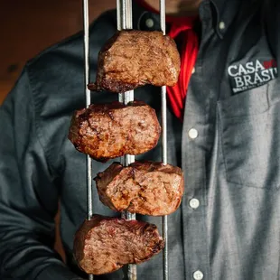 a man holding a rack of steaks