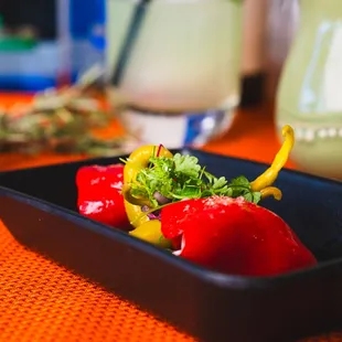 three peppers in a black bowl