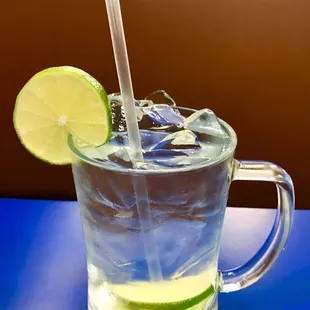 a glass of water with a lime slice and a straw