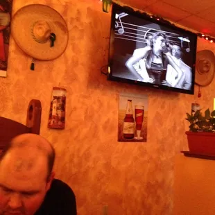 a man sitting at a table in front of a television