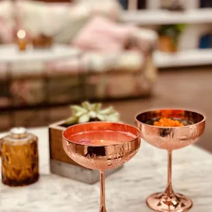 two copper wine glasses on a marble table