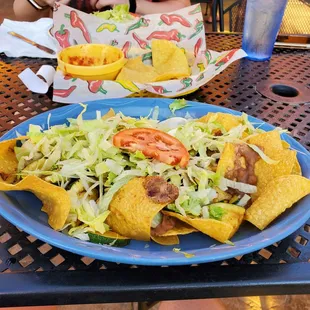 a plate of nachos and a bowl of salad