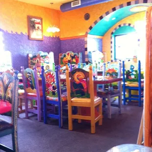 brightly colored tables and chairs in a brightly decorated restaurant