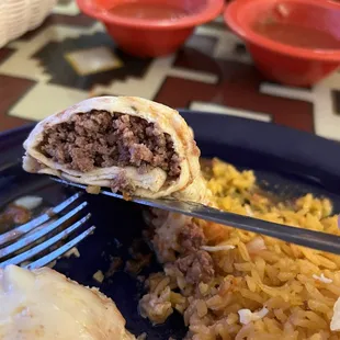 a hand holding a fork and a plate of food