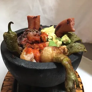 a black bowl of food on a plate