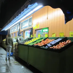 a woman walking past a fruit stand
