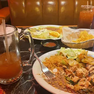 a plate of mexican food and a glass of orange juice