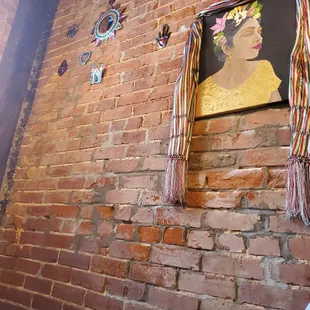 a brick wall with a painting of a woman