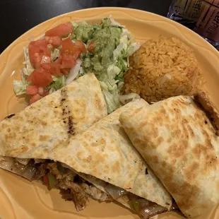 The chicken super quesadilla fajita : a side of rice - with onions in it , lettuce, tomatoes, and guacamole