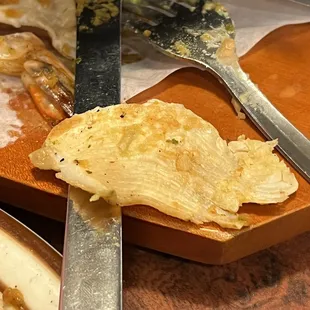 a slice of pizza and a knife on a cutting board