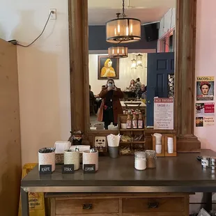 a counter with a mirror and coffee cups on it