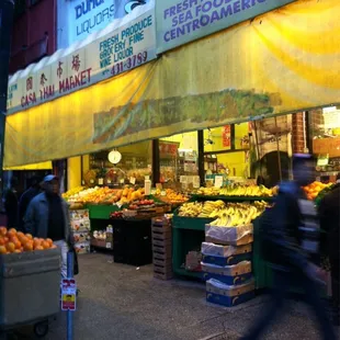a man walking past a fruit stand