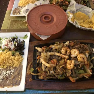 Combination fajitas steak shrimp and chicken beans rice arugula salad and no sour cream tortillas came in container they were still cold