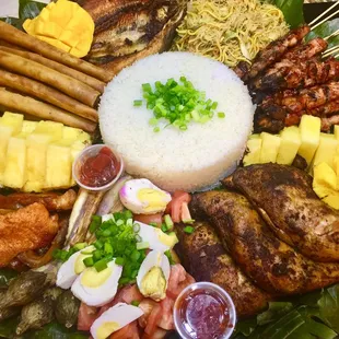 Bilao meal: pork bbq sticks, lumpia, pancit, eggplant, tomato &amp; salted egg, pork tocino, fbangus, mango, spineapple, rice, chicken