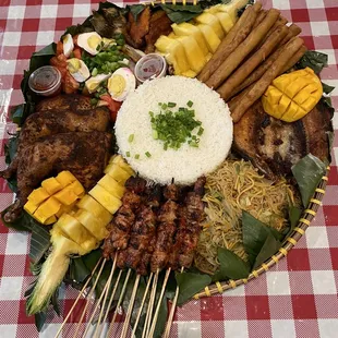 Bilao meal: pork bbq sticks, lumpia, pancit, eggplant, tomato &amp; salted egg, pork tocino, fbangus, mango, spineapple, rice, chicken