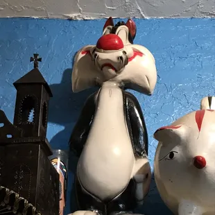 a cat and a cat statue on a shelf
