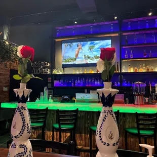 three vases of roses in front of a bar