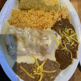 La valor- chimichanga with queso , cheese /onion enchilada , rice , refried beans , sour cream chicken burrito and a taco.