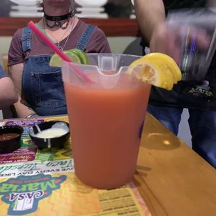 a woman sitting at a table with a drink
