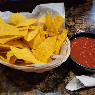 a basket of tortillas and a bowl of salsa