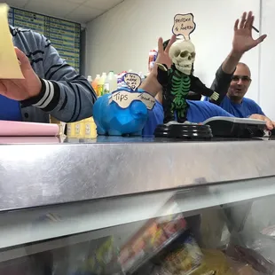 a man in a skeleton mask behind a counter