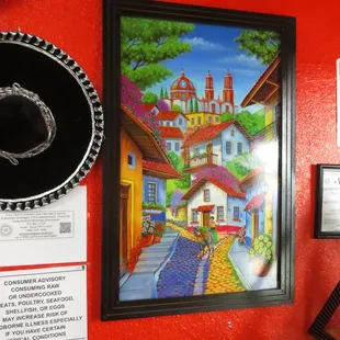 a red wall with a picture of a mexican village