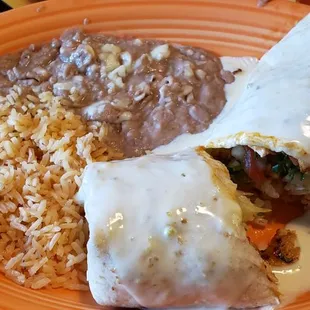 Lunch#9 large grilled ck burrito with pico and lettuce types with cheese sauce and comes with rice and beans on side.