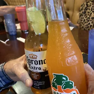 a person holding two bottles of mexicana