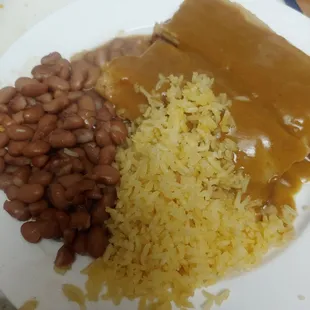 Pork tamales with gravy, rice and beans.