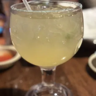 a glass of margarita with a straw