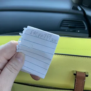 a hand holding a piece of note paper