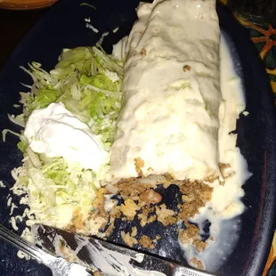 a burrito and salad on a blue plate
