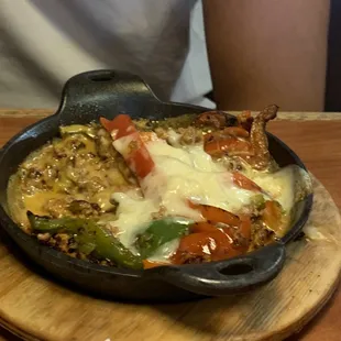 a skillet of food on a wooden board