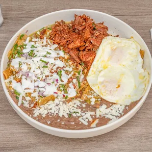Green Chilaquiles.
Chilaquiles topped with onion, cilantro, crema and cheese.