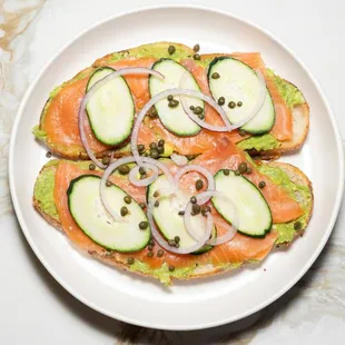 Salmon & Avocado Toast
Two slices of sourdough bread toasted, our special avocado spread, thin cucumber slices, and capers.