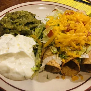 Chicken Flautas with guacamole and sour cream, served with frijoles.