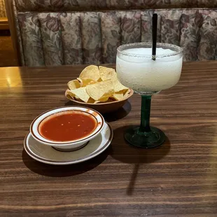 a table with a bowl of salsa and a bowl of chips