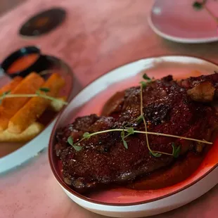 a plate of steak with a side of waffles