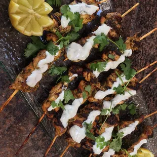 Tandoori style chicken skewers with Raita Sauce and Cilantro.