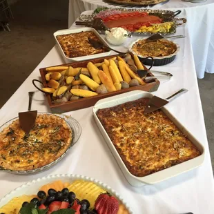 Wedding brunch of vegetarian quiche and spinach bacon quiche, blue corn green chile muffins and yellow corn muffins and bagels and lox.
