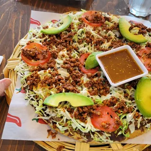 a hand holding a plate of mexican food