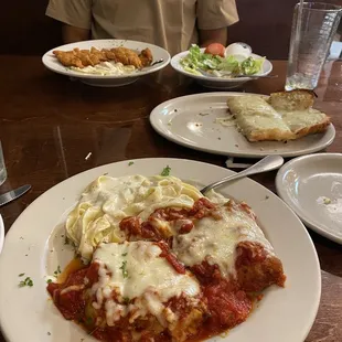 Pasta Trio nearest Fettuccine Alfredo w/fried chicken Garlic breadsticks to the right